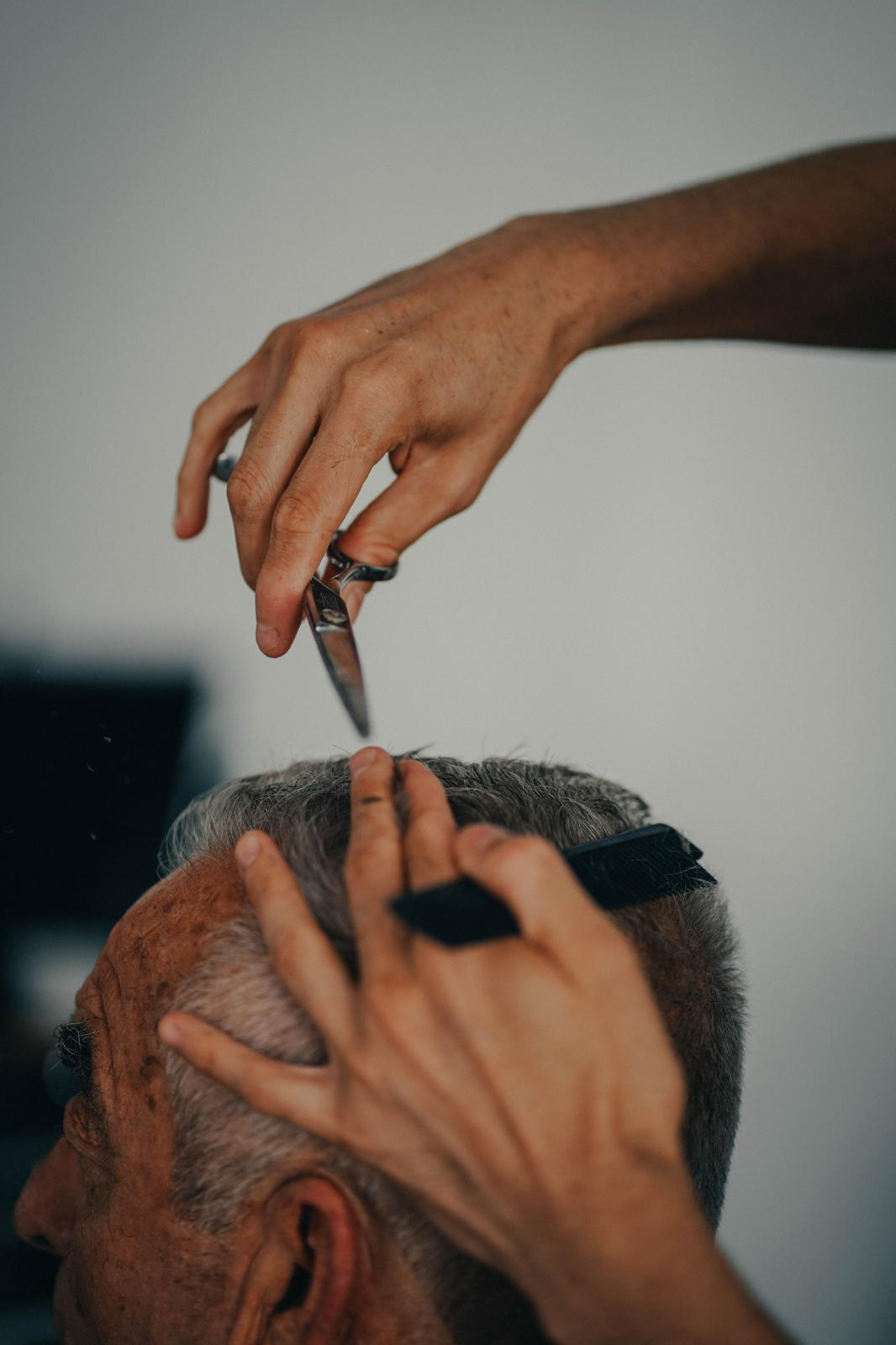 Primer plano de tijera y peine durante un corte